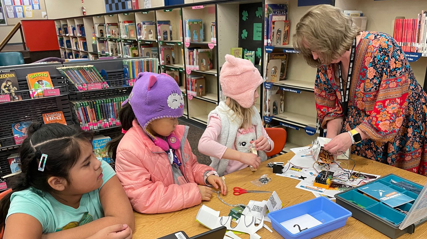 Kristi Labadie helps some of her robotics engineers with a wiring issue.